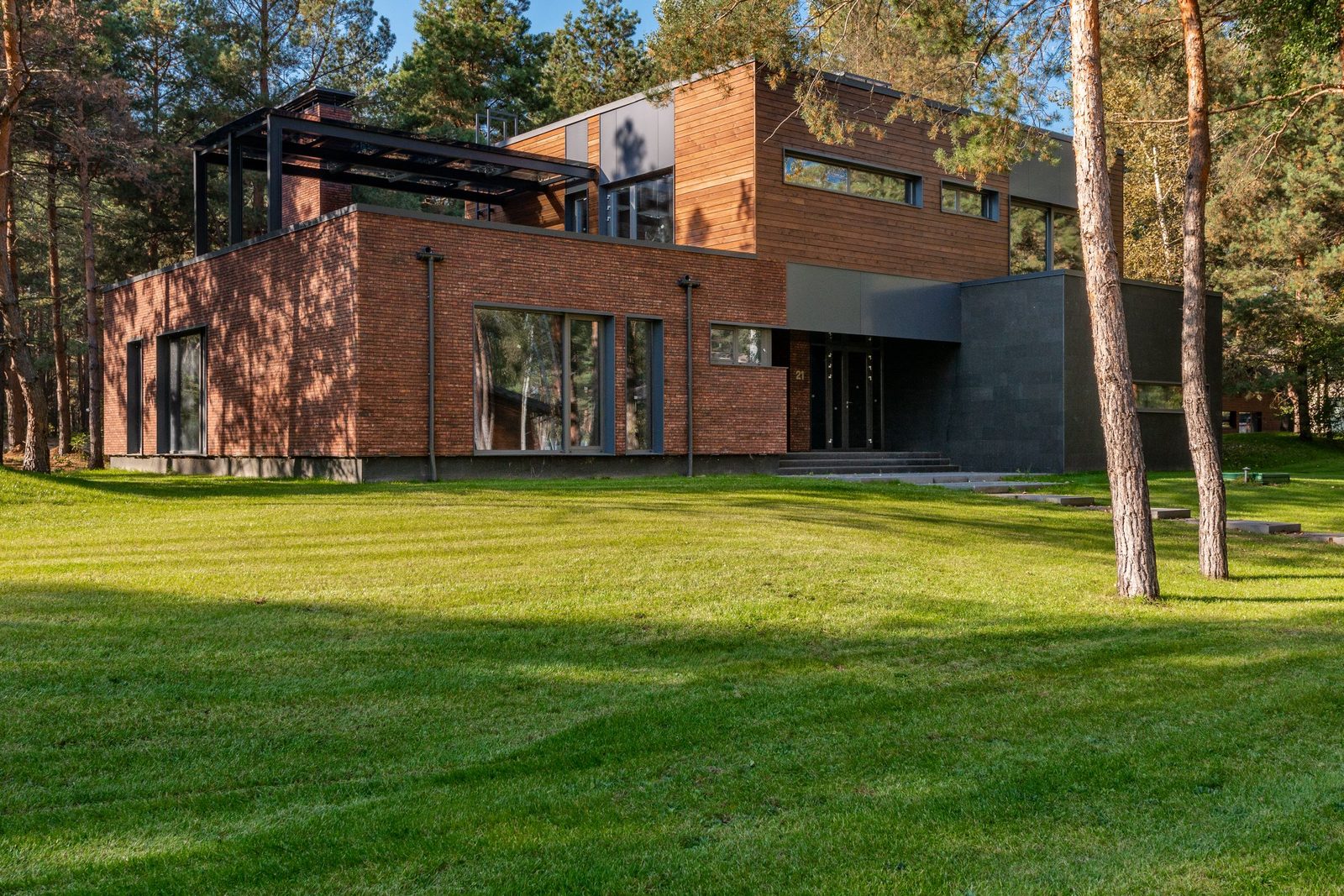 Modern brick and wood home set on a green lawn