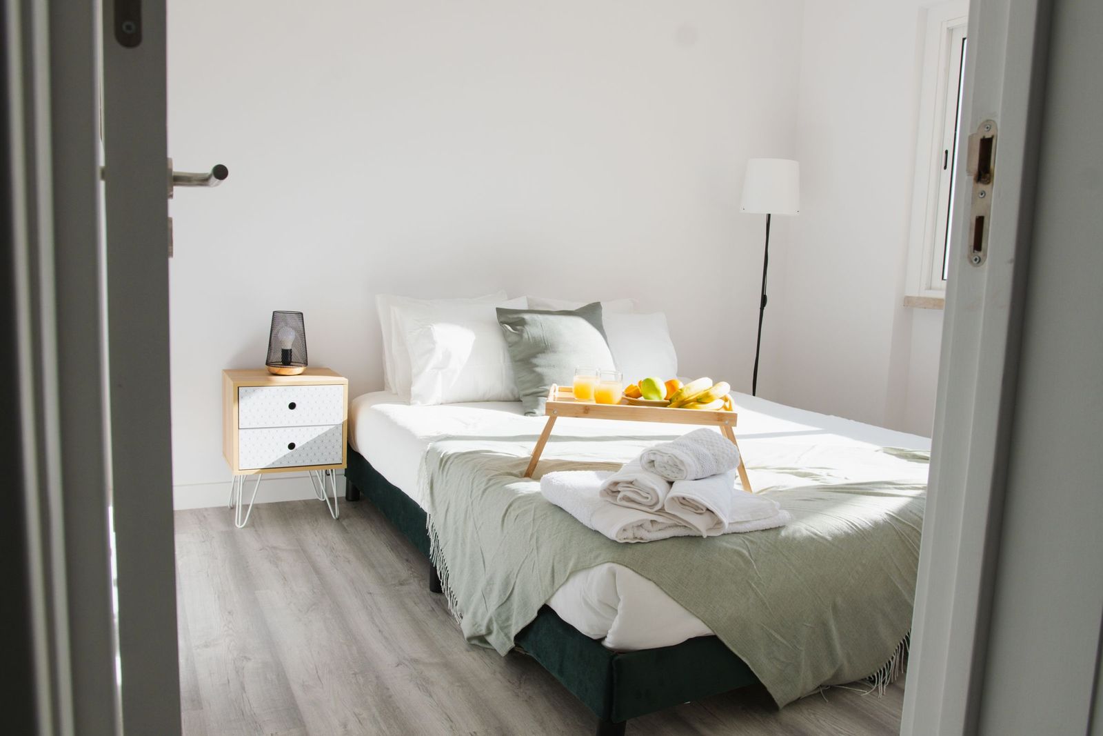 Bright, tidy bedroom with fresh linens and a breakfast tray, ready for a guest
